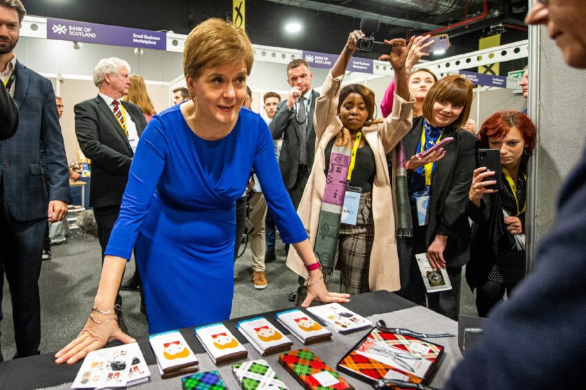 Photo shows SNP leader Nicola Sturgeon speaking to a stallholder at the SNP conference in Aberdeen.