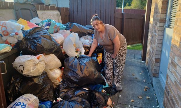 Donna Stewart with the rubbish on Hillbank Place. Image: Lindsey Hamilton/DC Thomson.