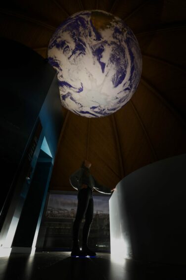 Photo shows a large globe of the Earth suspended from the ceiling at the Discovery Dome in Dundee.