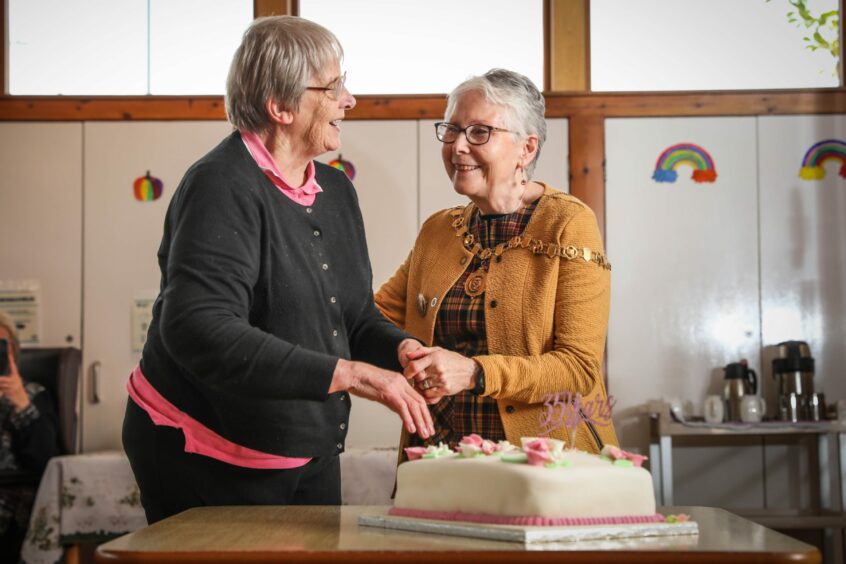 The centre's longest-serving member Lily Morrison and Depute Angus Provost Linda Clark cut the anniversary cake