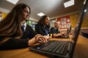 Kaja Przepiora, Indea Adeyosoye and Beth Skelly using their new laptops at Morgan Academy. Image: Mhairi Edwards/DCThomson.