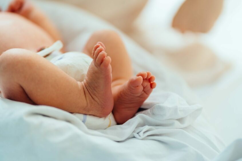 Photo shows a newborn baby's feet.