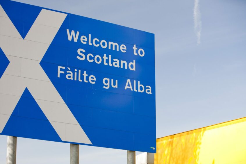 photo shows sign saying 'Welcome to Scotland' and 'Failte gu Alba' beside the M74 at Gretna Green.