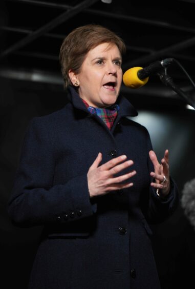 photo shows Nicola Sturgeon at a microphone.