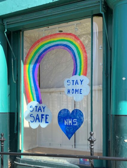 message in a shop window saying 'stay safe, stay home, NHS'