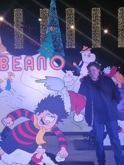 photo shows the writer Andrew Batchelor next to a cardboard cutout of Dennis the Menace throwing a snowball.