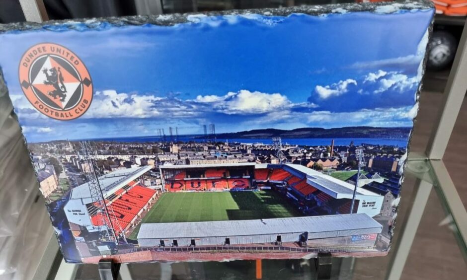 A stone slate with a colour image of Dundee United's Tannadice Park.