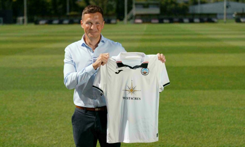 Andy Goldie, formerly of Dundee United, poses with a Swansea City jersey