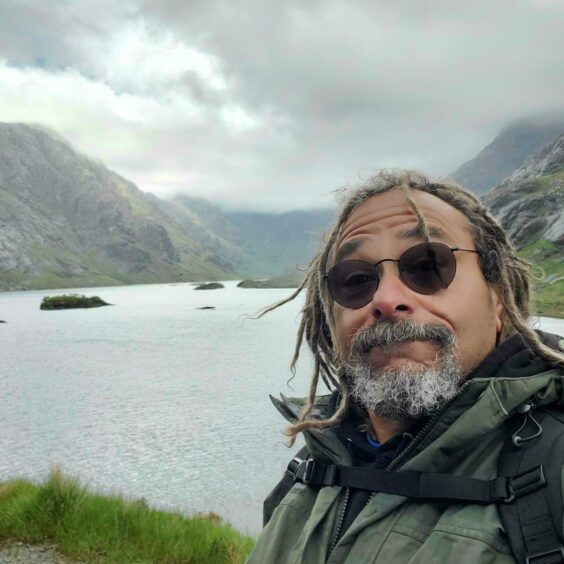 Bruce Fummey taking a selfie next to a loch and mist mountainside