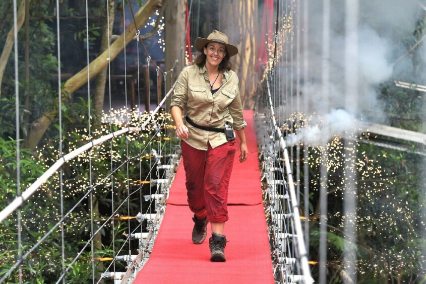 photo shows Kezia walking across a footbridge, with fireworks exploding in the background, after being voted out of I'm A Celebrity Get me Out Of Here.