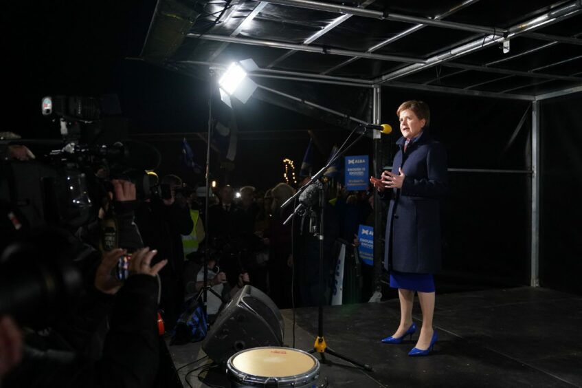 Photo shows Nicola Sturgeon on stage and speaking into a microphone at a rally.