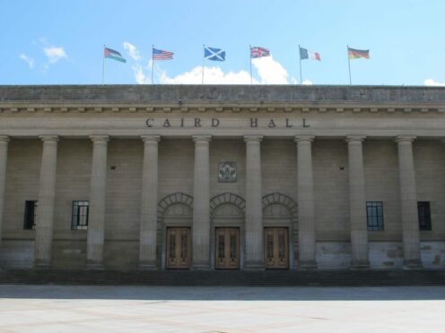 The Caird Hall with flags in the daytime.