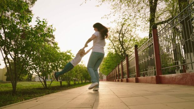 woman happily lifts and circles child around