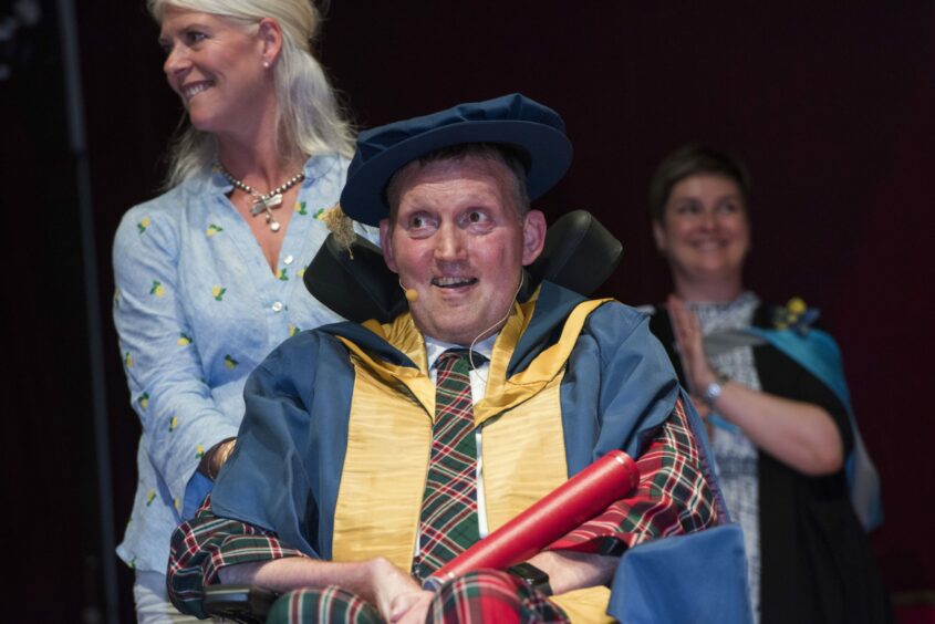 photo shows Doddie Weir being given an honorary degree by Abertay University.