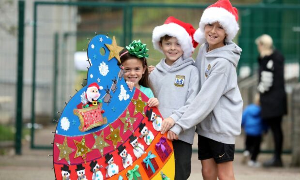 Eddison, 9, Remi, 7, and Minnie, 5, with Grange Primary School's bauble