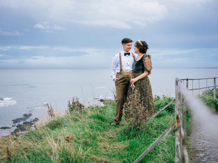 Han Smith and Jennifer Andreacchi on the coastline of St Andrews during wedding day.