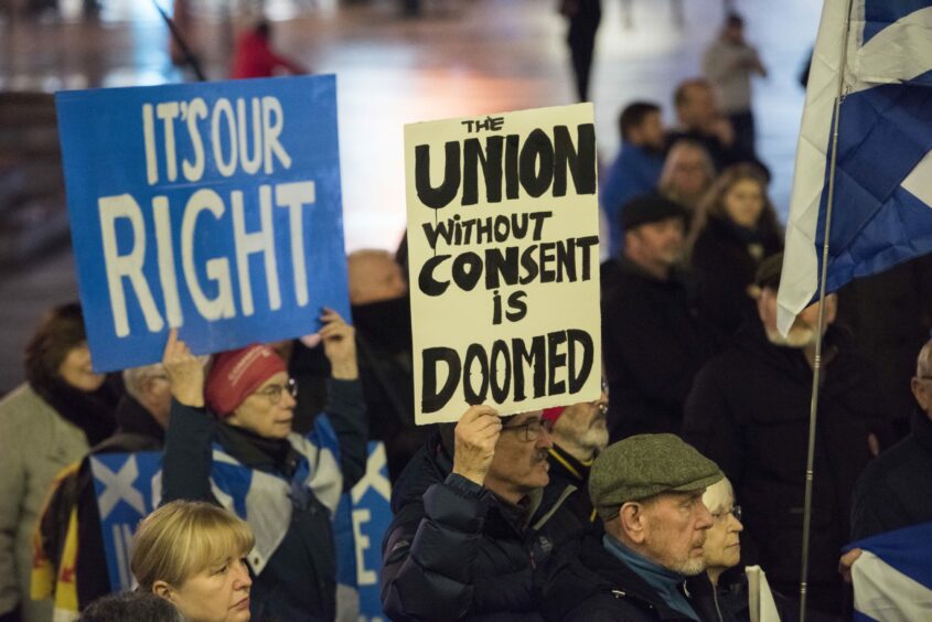 Independence supporters holding placards with slogans such as 'The Union without consent is doomed'.