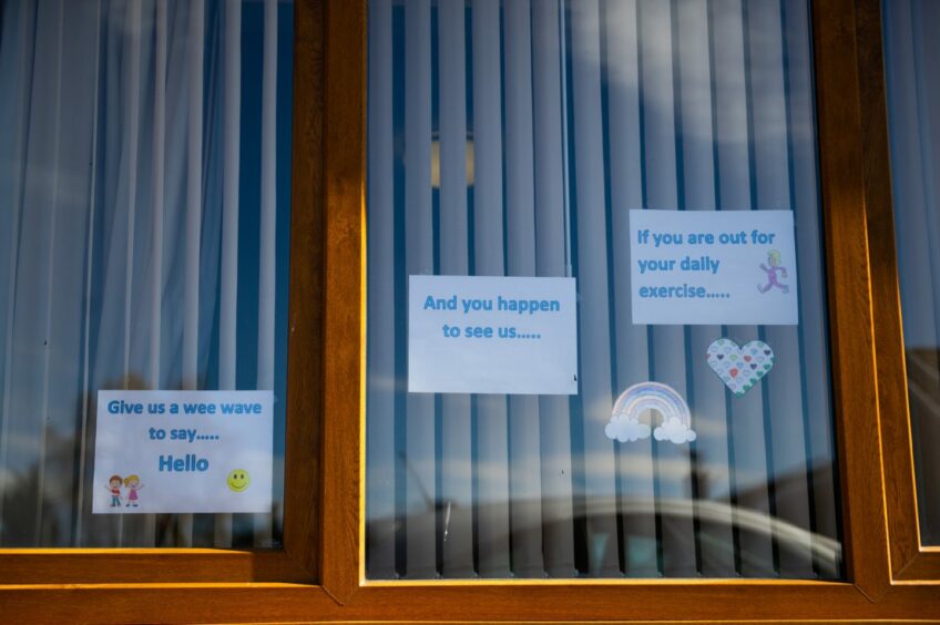 photo shows signs in Balhousie Glens care home window, saying 'If you are out for your daily exercise', 'And you happen to see us', 'Give us a wee wave to say hello'.
