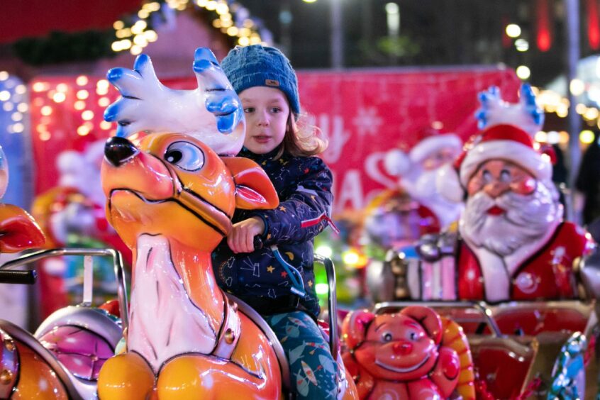 small child on reindeer merry-go-round figure