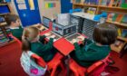 Primary school children log on to laptops. Image: Kim Cessford / DCT Media.