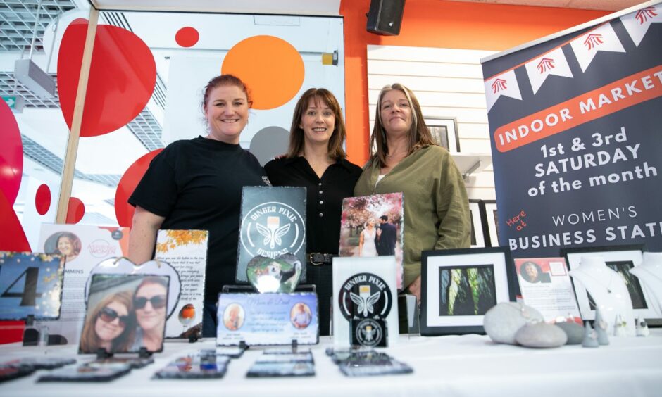 Three women behind a table featuring Ginger Pixie Design products.
