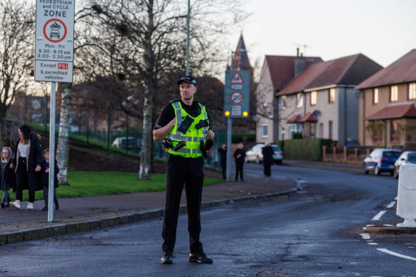 Police officers were positioned to educate and warn drivers of the new restrictions in streets outside Downfield Primary. Image: Kenny Smith/ DC Thomson