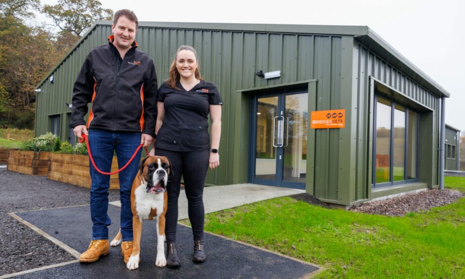 Bruce, Hannah and their boxer Barry in front of their new 3 Bridges Vets practice.
