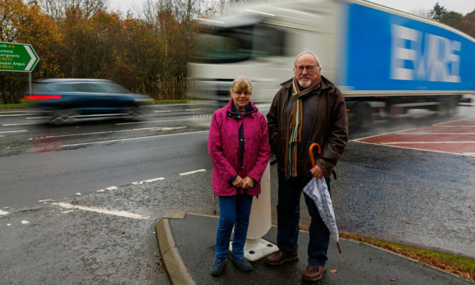 Alison Bryden and Alasdair Wylie standing beside fast moving traffic on the A9