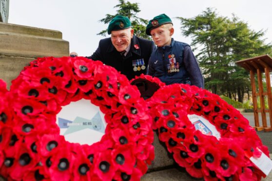 9 year old Archie Kirk (wearing his father Brian's medals and beret) and Cllr Rod Cavanagh take in the wreaths following the ceremony. Picture taken by Kenny Smith/ DC Thomson
