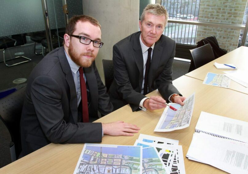 photo shows Bryan Copland and Alan Watt, Dundee Waterfront development coordinator, seated at a desk looking at plans in 2013