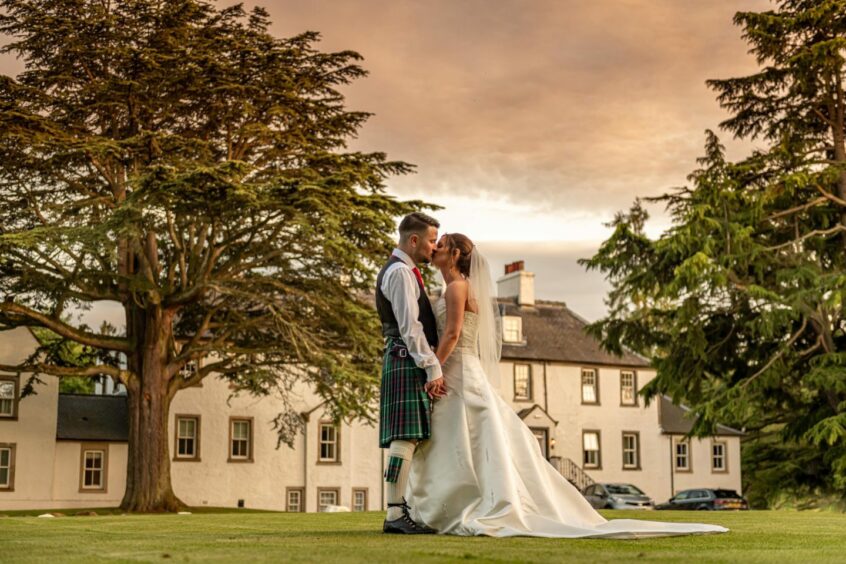 Couple standing on grounds for wedding photography.