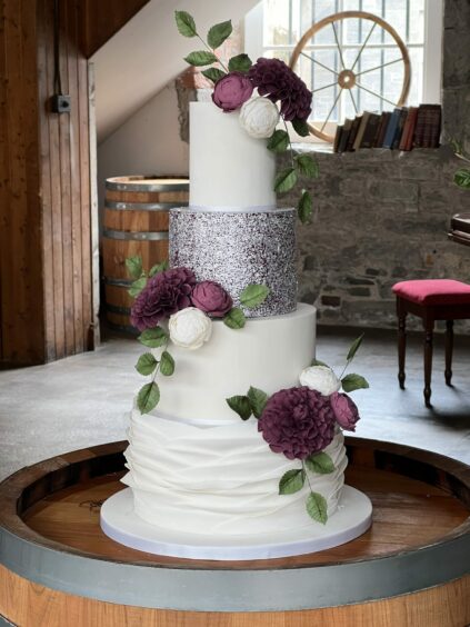 A cake by Philippa Rose Cake design with flower petals and eucalyptus.
