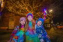 Twins Charlotte (left, aged 4) and Brody Clark (right, aged 4) with older sister Aria (aged 5, middle) attending Alyth Christmas lights switch on. Image: Steve MacDougall / DC Thomson.