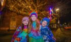 Twins Charlotte (left, aged 4) and Brody Clark (right, aged 4) with older sister Aria (aged 5, middle) attending Alyth Christmas lights switch on. Image: Steve MacDougall / DC Thomson.