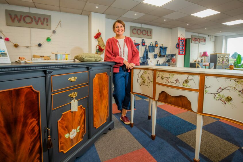 Artist Clare Scott standing by two of her own upcycling projects. She shares how to learn to upcycle yourself.