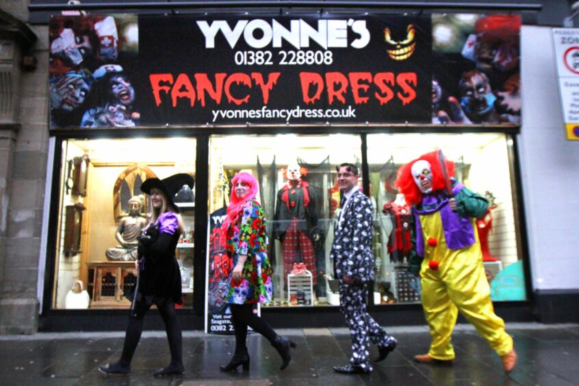 Photo shows people dressed as a witch, a clown and in other costumes outside Yvonne's fancy dress shop in Dundee.