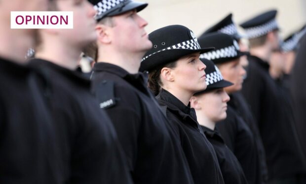 Photo shows a number of police officers standing to attention.