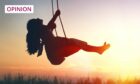 Photo shows a girl on a swing silhouetted against a sunset sky.