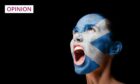 photo shows woman with mouth wide open and a Scotland flag painted on her face.