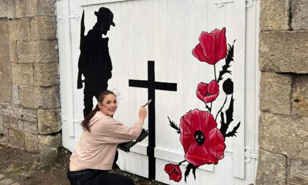 Amanda Sloan, 28, painted the Remembrance Day mural. Image: Ryan Robertson/Facebook.