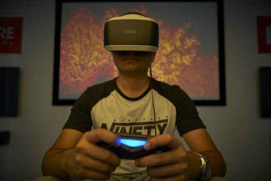 A photo of an Abertay University postgraduate student on a VR headset