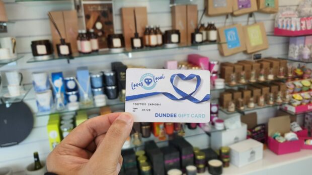 Someone using the Dundee Loves Local card to go shopping in Dundee, Scotland