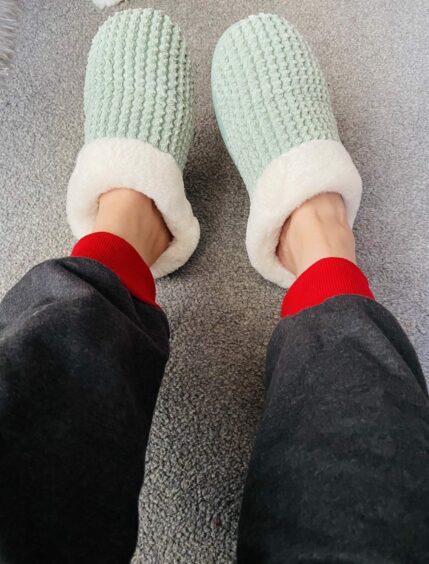 photo shows a woman's feet in a pair of slippers.