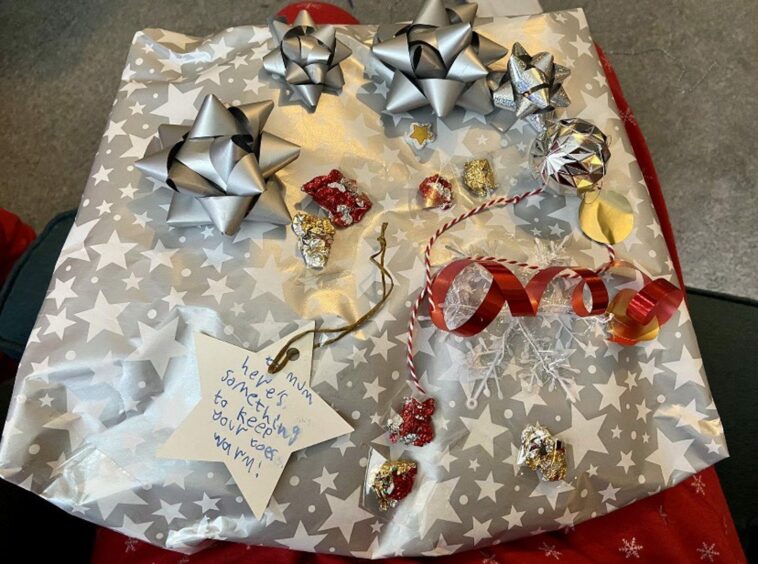 photo shows a parcel wrapped in silver paper with a gift card which reads 'To mum, here's something to keep your toes warm'.