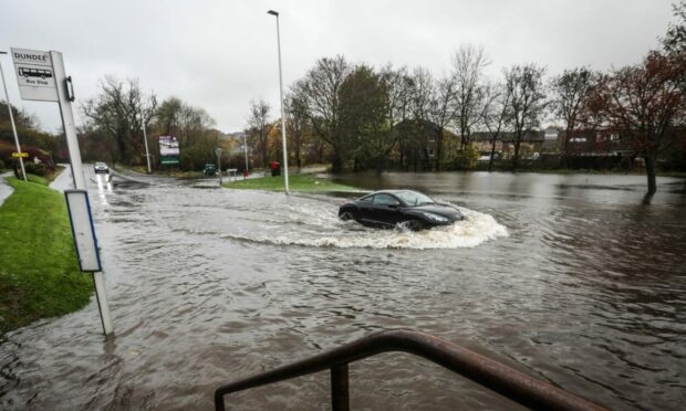 A car driving through floodwater at Berwick Drive in Dundee. Image: Mhairi Edwards/DC Thomson.