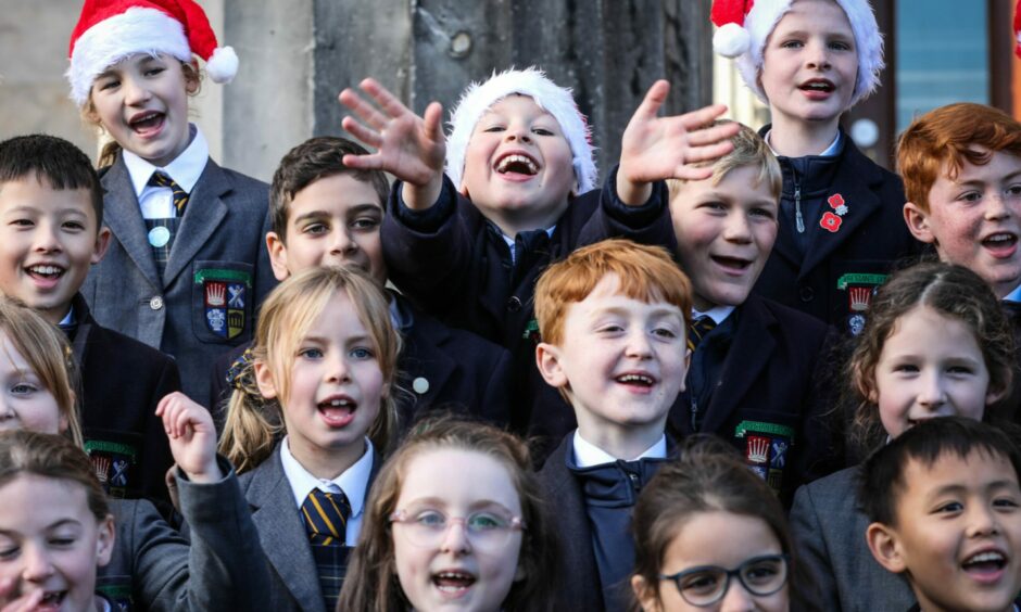 Photo shows children in the High School of Dundee choir, some wearing Santa hats.