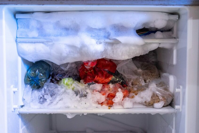 photo shows an overstuffed freezer with ice spilling out the door.