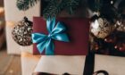 Tickets to shows in Dundee wrapped in a bow under a Christmas tree.