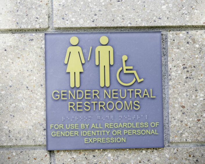 Photo shows a sign for gender-neutral restrooms.