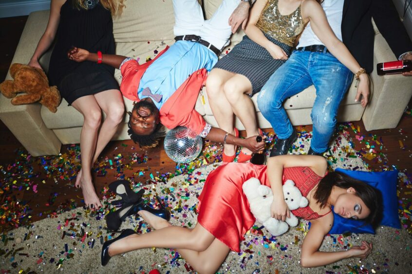 Photo shows young people collapsed on a sofa and on the floor with signs of a rowdy party all around them.